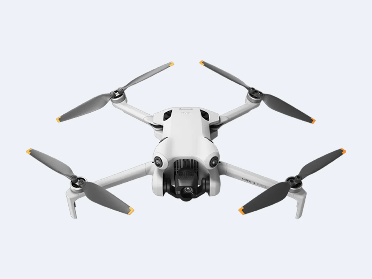 DJI Mini 4 Pro visto de frente, com sensores nas laterais e hélices abertas