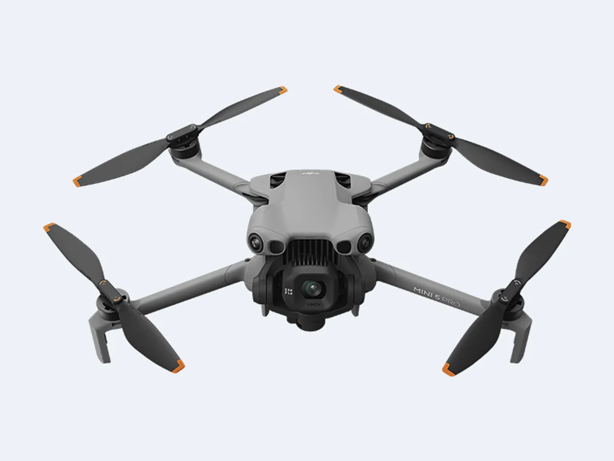 DJI Mini 5 Pro visto de frente, com câmera e gimbal sob o corpo e hélices abertas