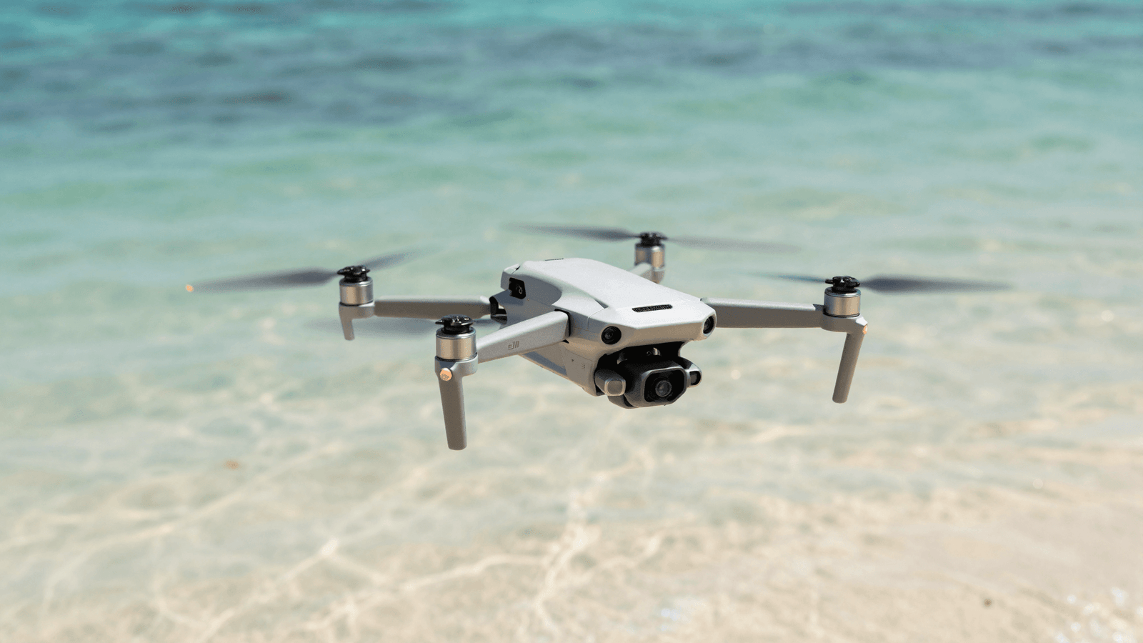 Drone DJI Mini pairando sobre a praia