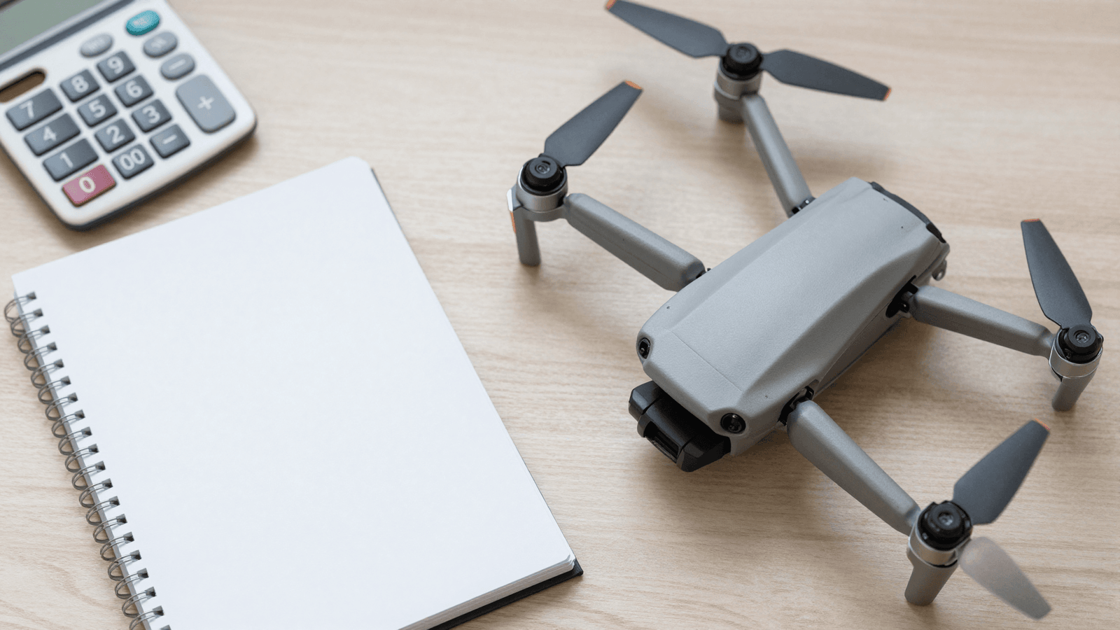 Equipamento DJI e calculadora representando os custos da operação