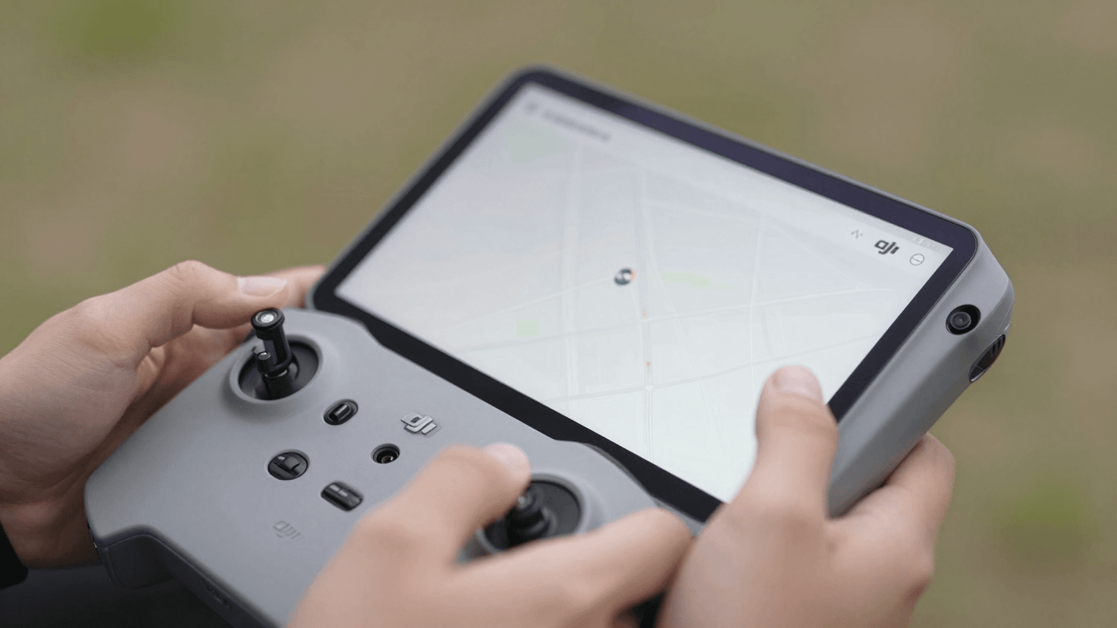 Mãos operando o controle DJI com tablet para solicitar autorização de voo