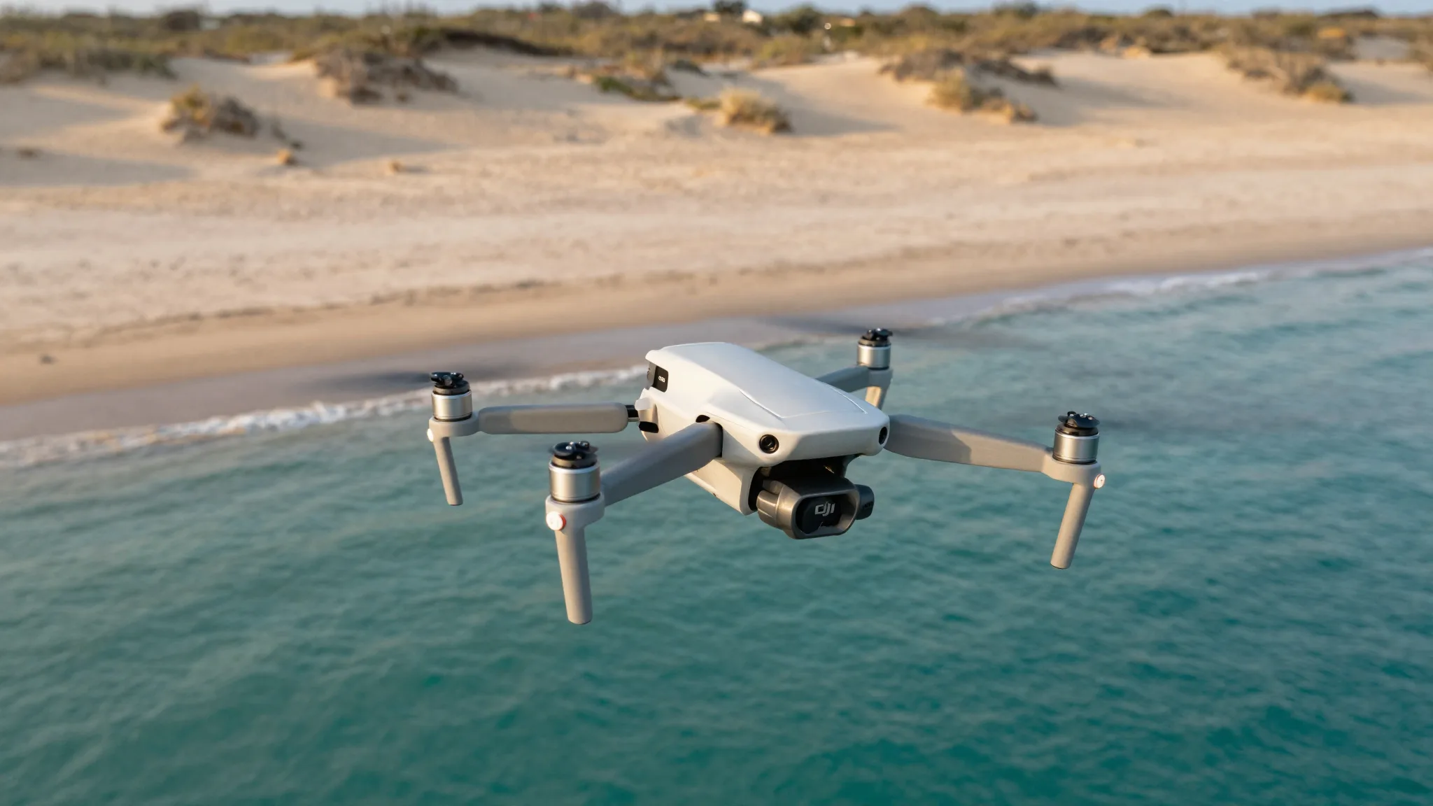 Drone DJI sobre uma praia natural deserta com dunas e água cristalina