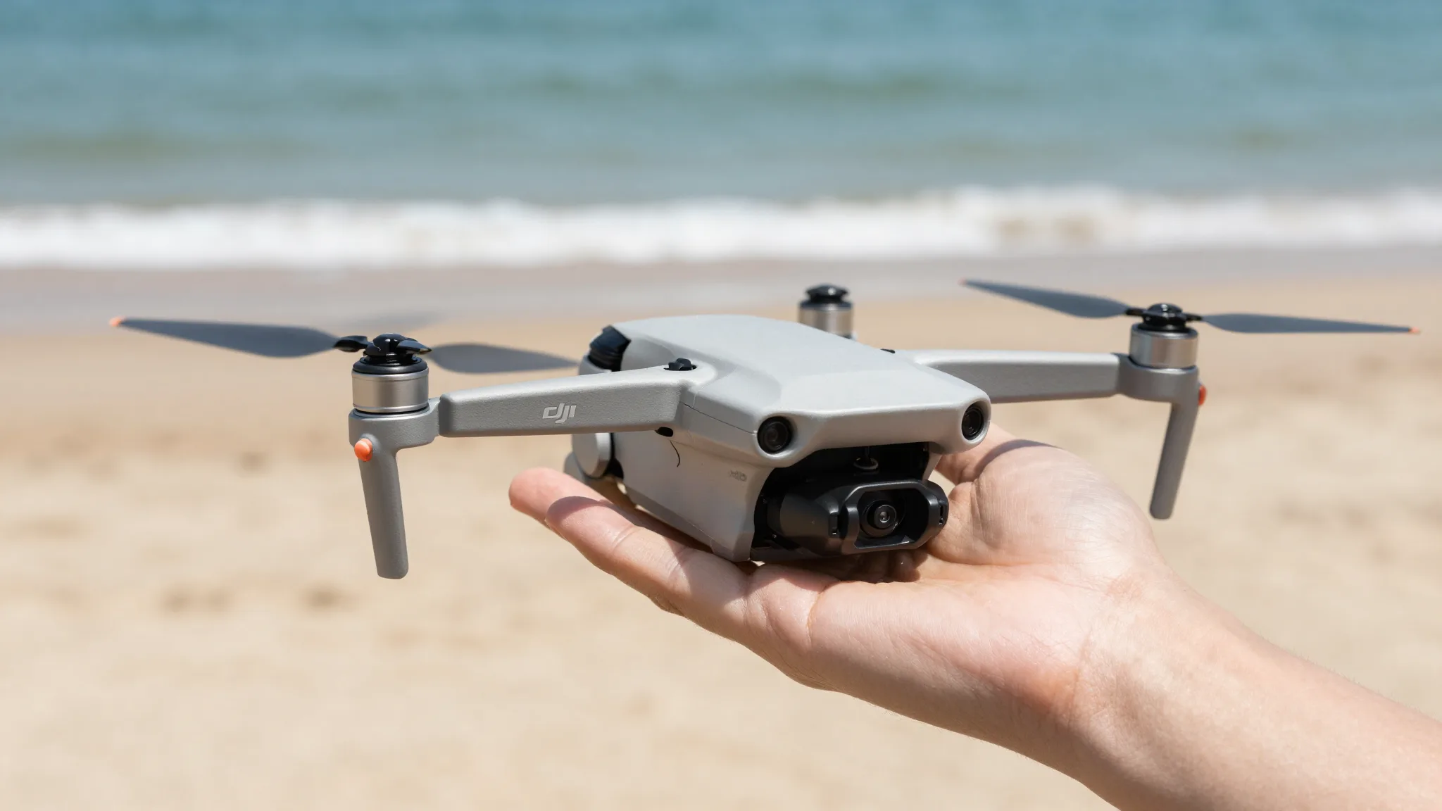 Piloto decolando um drone DJI Mini da palma da mão na areia da praia