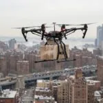 Drone avancado de carga sobrevoando area urbana com uma entrega, ilustrando a categoria certificada de alto risco