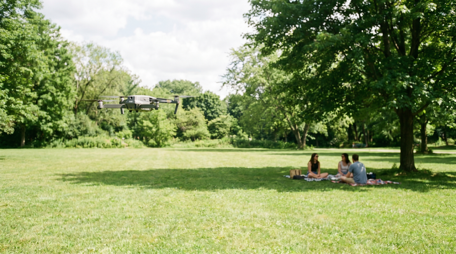 Drone pairando a uma distancia segura de um pequeno grupo de pessoas num parque