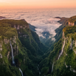 Vista aerea do Canion Itaimbezinho com paredoes verdes e mar de nuvens ao entardecer