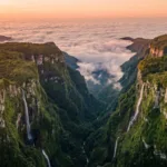 Vista aerea do Canion Itaimbezinho com paredoes verdes e mar de nuvens ao entardecer