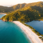 Vista aerea do litoral de Florianopolis com praia e mar turquesa ao entardecer