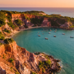 Vista aerea das falesias vermelhas e do mar turquesa da Praia de Pipa ao entardecer
