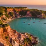 Vista aerea das falesias vermelhas e do mar turquesa da Praia de Pipa ao entardecer