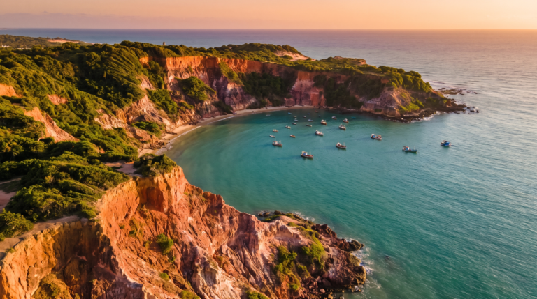Vista aerea das falesias vermelhas e do mar turquesa da Praia de Pipa ao entardecer