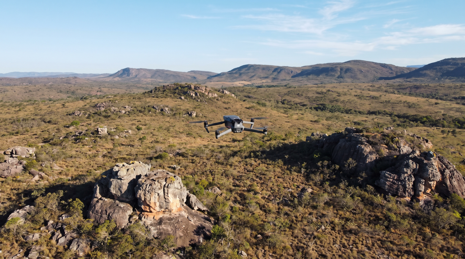 Drone DJI-style voando sobre o cerrado da APA no entorno da Serra do Cipo