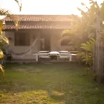 Drone leve estilo DJI Mini voando sobre um quintal ao entardecer, ilustrando o fim da isencao do sub-250g em 1 de julho de 2026
