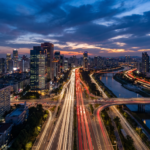 Vista aerea de uma cidade ao entardecer com rastros de luz nas avenidas na blue hour