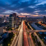 Vista aerea de uma cidade ao entardecer com rastros de luz nas avenidas na blue hour