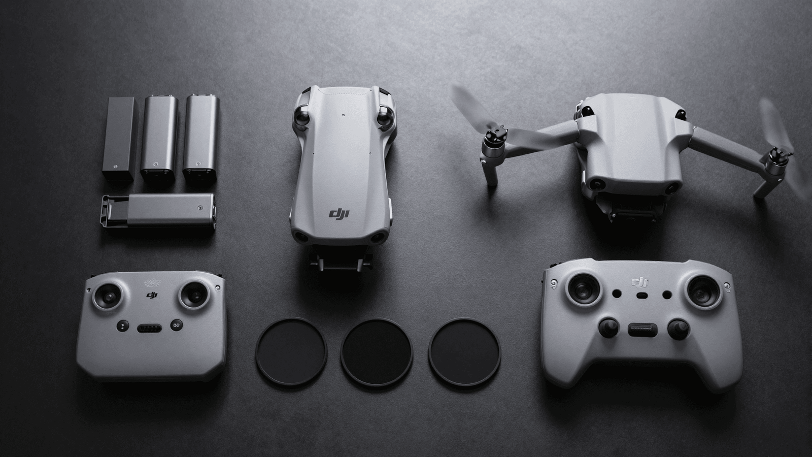 Kit completo de operação com drone, baterias, controle e filtros organizados sobre a mesa