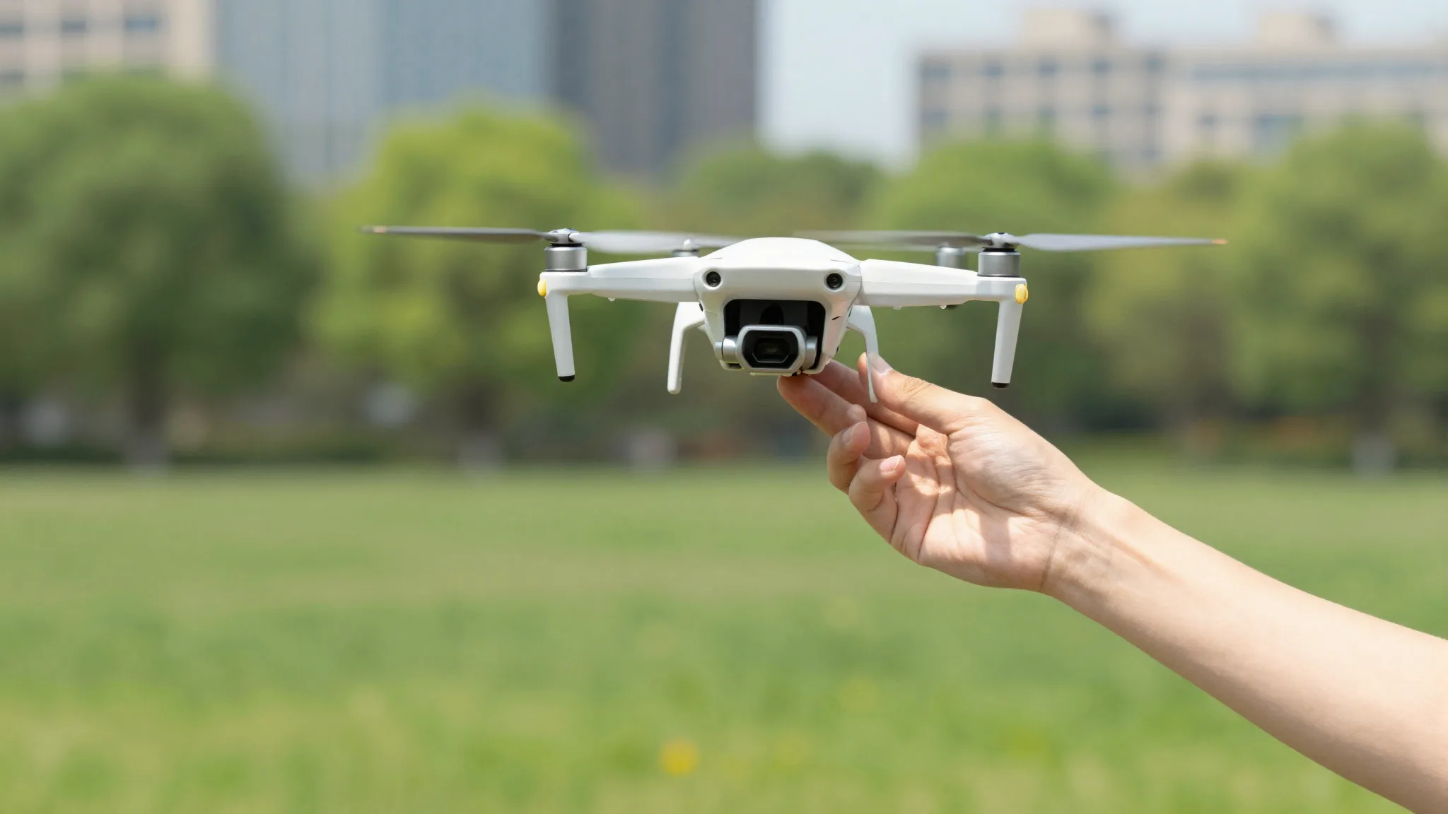 Piloto lançando um mini drone da mão em um parque urbano ensolarado