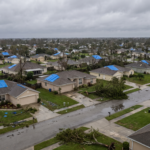 Vista aerea de um bairro residencial apos uma tempestade com telhados danificados