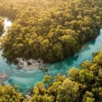Vista aerea de um rio cristalino cercado de mata verde perto de Bonito ao entardecer