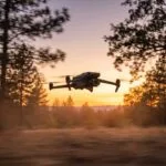Drone DJI-style em voo rapido contra o por do sol com faixas de borrao de movimento ao fundo
