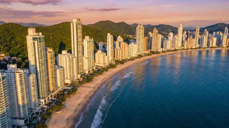 Vista aerea do skyline de arranha-ceus e da praia de Balneario Camboriu ao entardecer