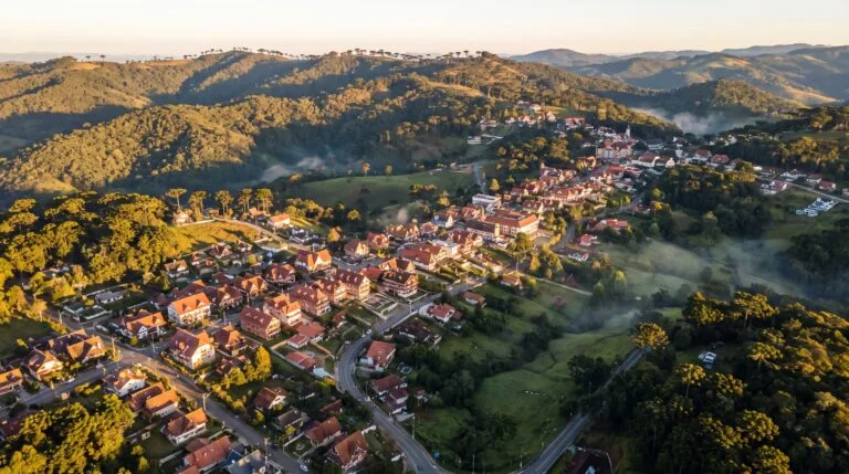 Vista aerea das montanhas com araucarias e da cidade de Campos do Jordao ao entardecer