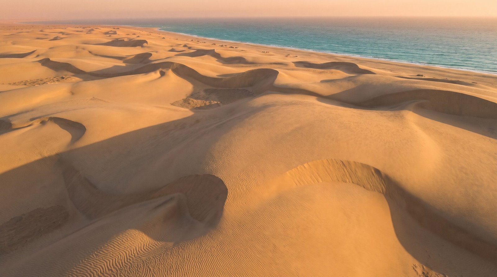 Foto aerea das dunas do litoral cearense com sombras longas de manha cedo