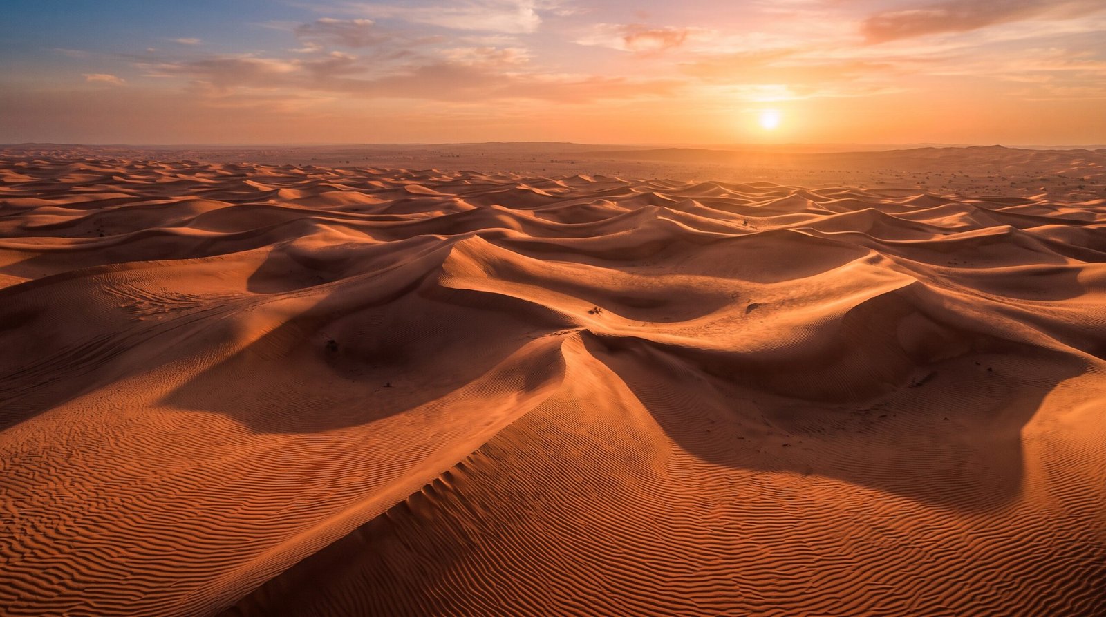 Foto aerea das dunas vermelhas do deserto perto de Dubai ao por do sol