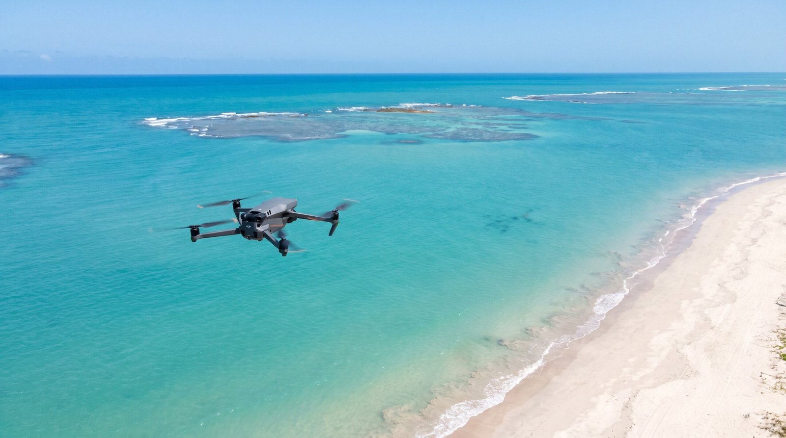 Drone DJI-style voando alto sobre a praia aberta de Maragogi, longe de pessoas