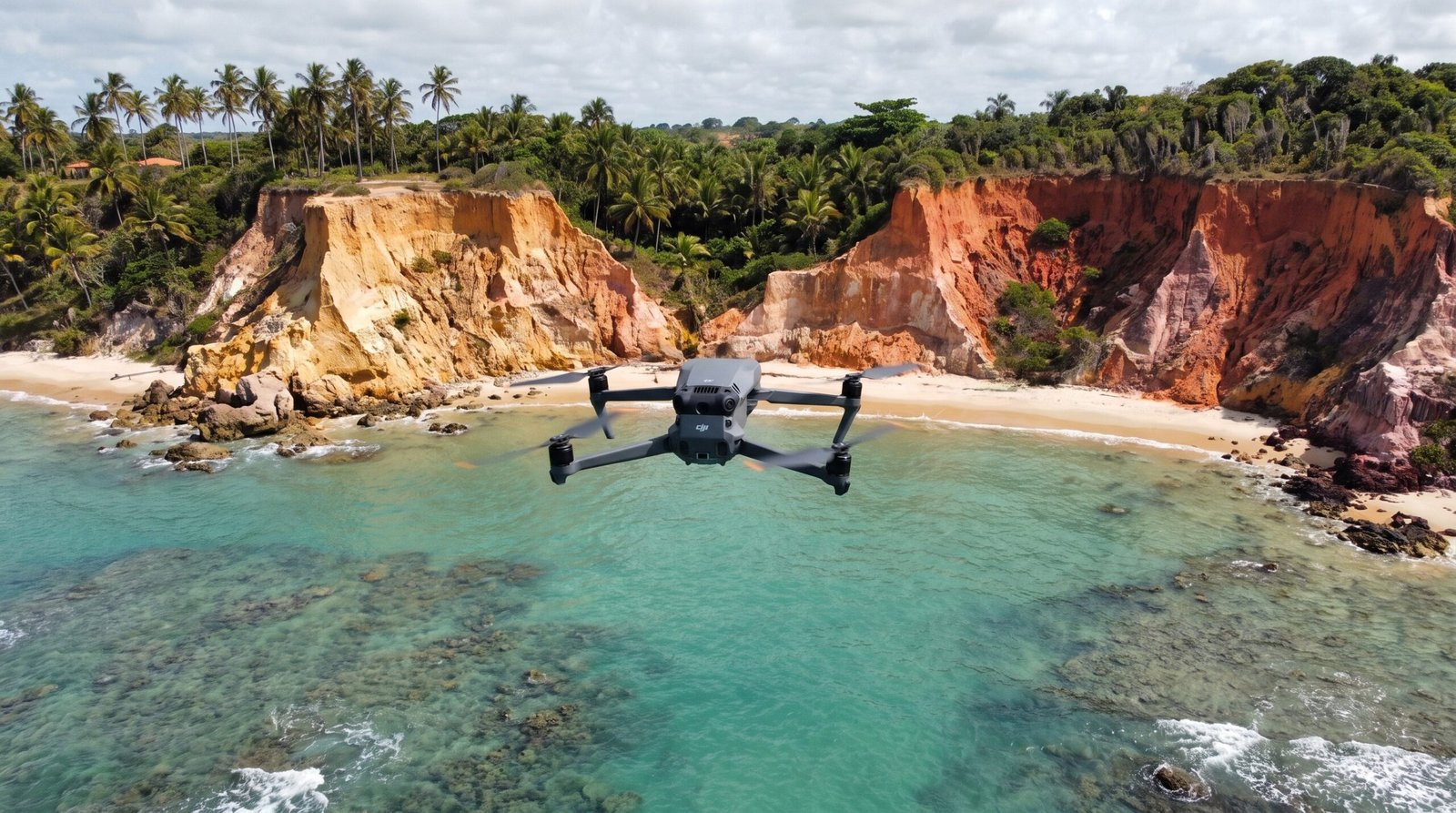Drone DJI-style voando sobre uma praia de falesias perto de Trancoso, longe de pessoas