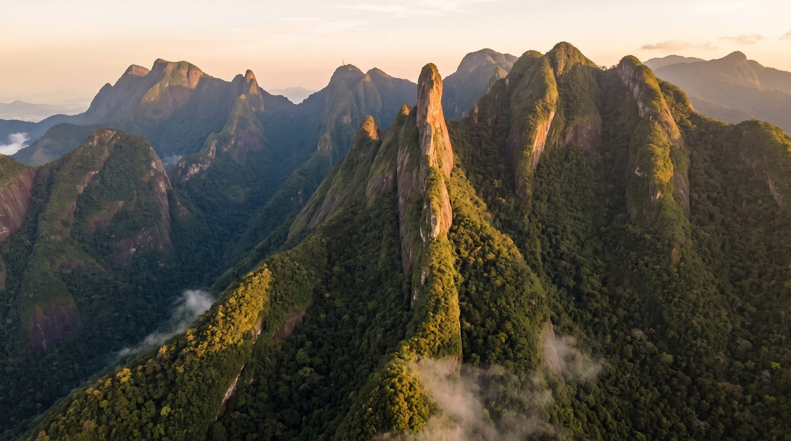 Foto aerea dos picos verdes da Serra dos Orgaos com o Dedo de Deus ao entardecer