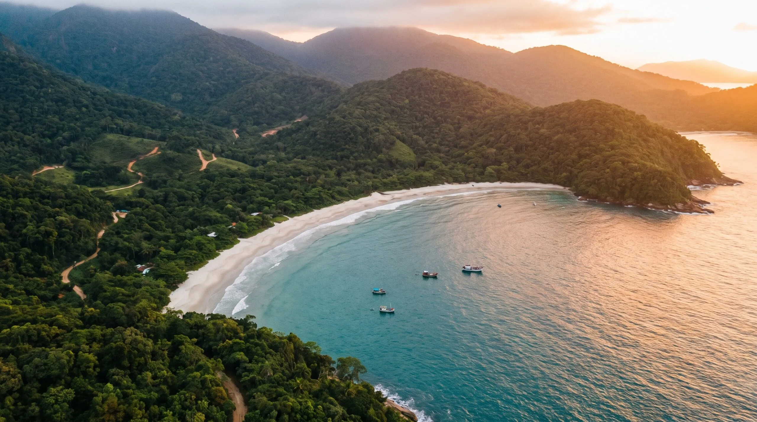 Foto aerea de uma praia tranquila de Ubatuba com a mata e o mar ao entardecer