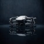 Drone dobrável sob um único foco de luz em estúdio escuro, clima de lançamento misterioso