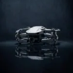 Drone dobrável sob um único foco de luz em estúdio escuro, clima de lançamento misterioso