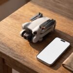 Drone dobrado sobre a mesa ao lado de um celular com calendario