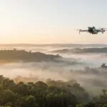 Paisagem ampla ao amanhecer com um drone ao longe