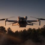 Drone voltando ao entardecer sobre uma linha de arvores