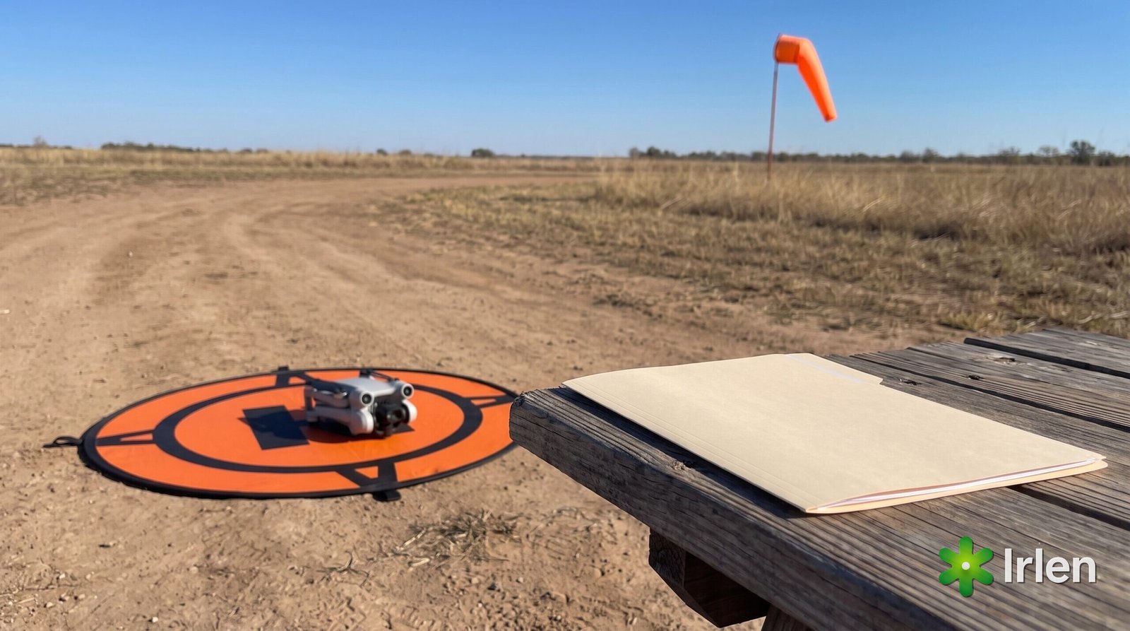 Drone no pad de pouso ao lado de pasta de documentos e biruta