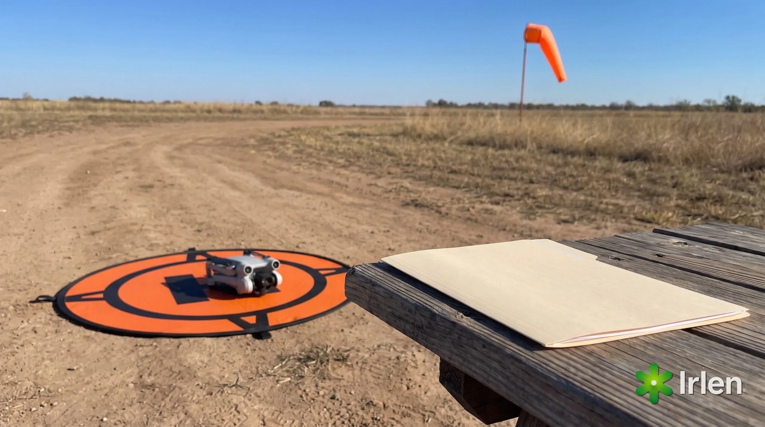 Drone no pad de pouso ao lado de pasta de documentos e biruta