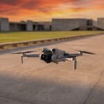 Drone cinza pequeno pairando sobre uma esplanada vazia ao entardecer