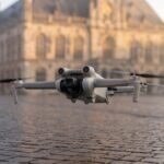 Drone decolando de uma praça municipal com prédio público ao fundo