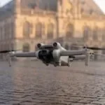 Drone decolando de uma praça municipal com prédio público ao fundo