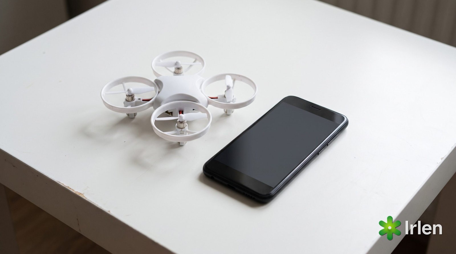 Quadricóptero branco de plástico ao lado de um celular sobre a mesa