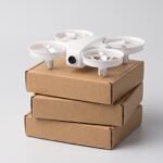 Pequeno quadricóptero branco de plástico sobre caixas de papelão