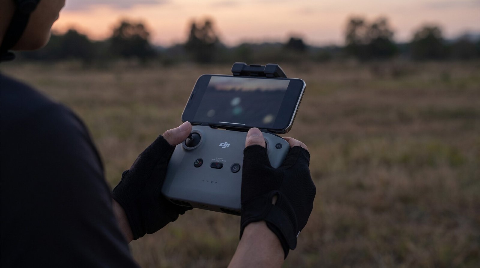 Mãos segurando o controle com o celular acoplado durante a busca