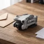 Drone cinza dobrado sobre uma mesa ao lado de documentos