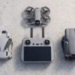Controle DJI RC 2 sobre uma mesa ao lado dos drones DJI Mini 4 Pro, Air 3S e Neo 2