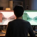 Designer diante de dois monitores com dois editores de foto quase iguais, ilustrando o clone do Photoshop feito com IA
