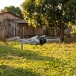 Drone DJI Mini 4 Pro parado no ar sobre o quintal de uma chácara