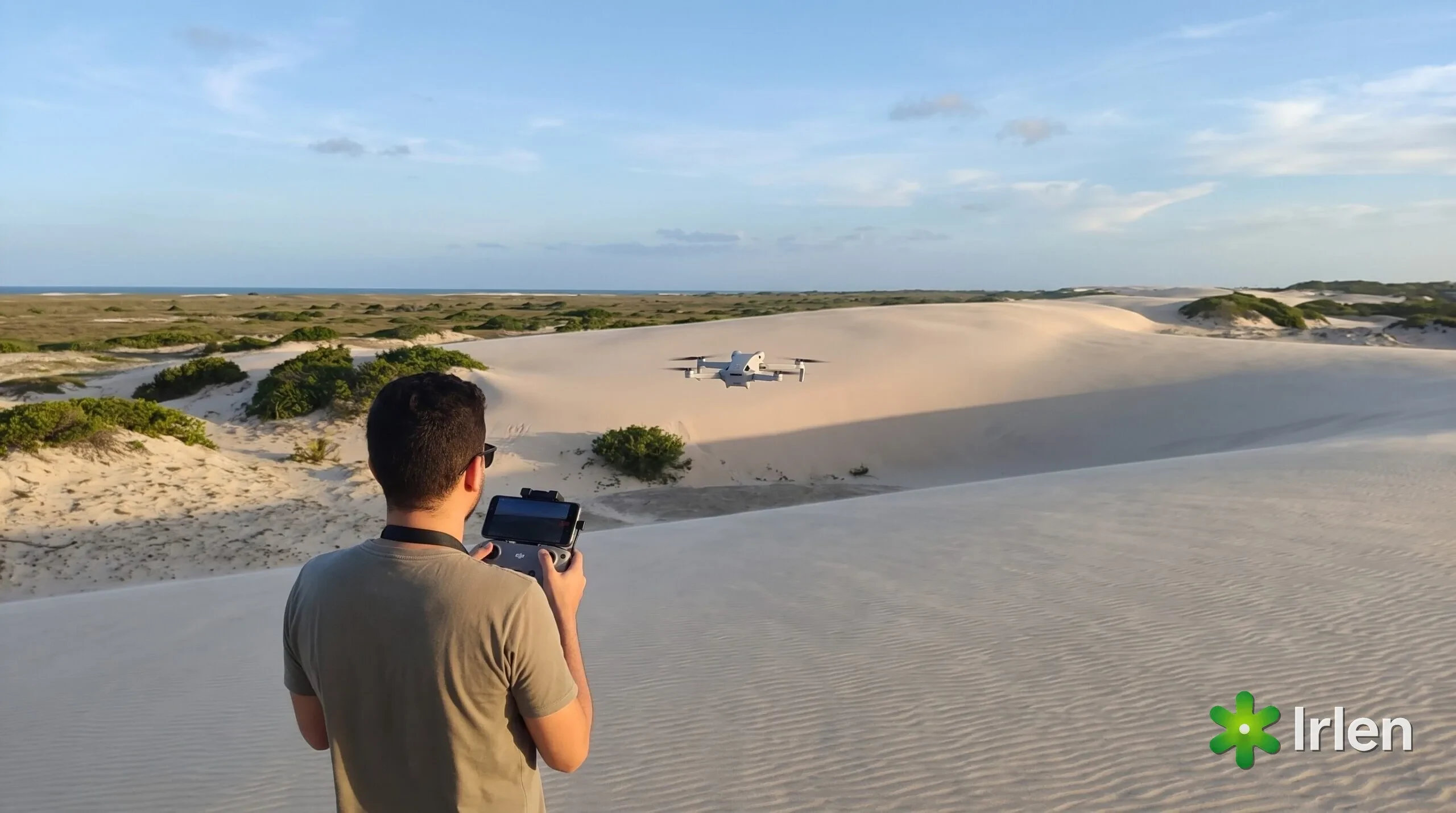Piloto de costas com controle DJI RC-N3 e drone Mini 4 Pro pairando nas dunas da Sabiaguaba, em Fortaleza